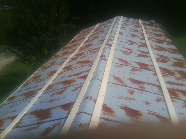 Rusted metal roof panels with new wood purlins before replacement — Storm Damage Roof Repair in Means by Roofing Brothers