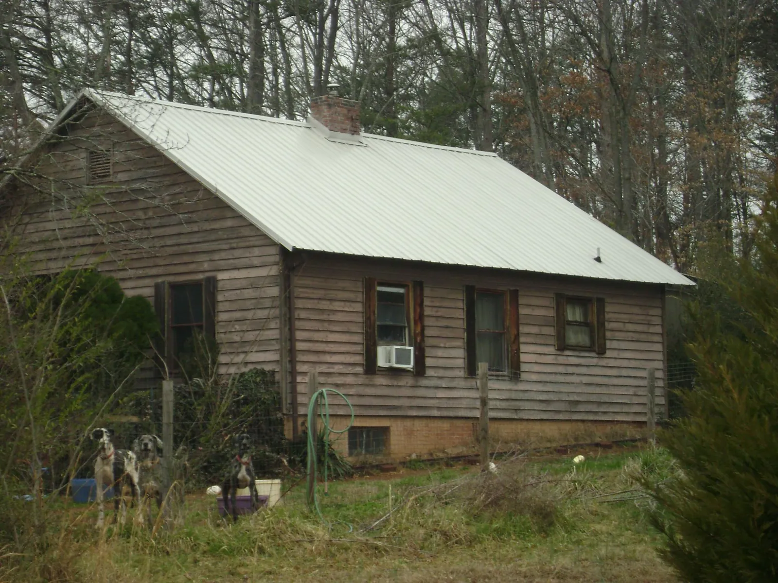 White metal roof on an old wood sided farmhouse, from a Metal Roof Installation job in Means